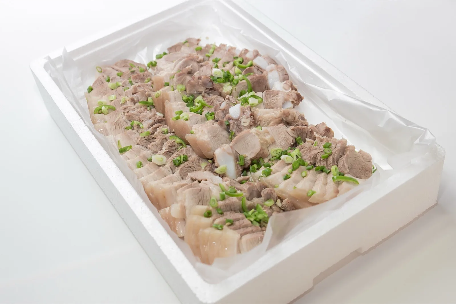 스티로폼 상자에 담긴 썰어 놓은 수육과 파